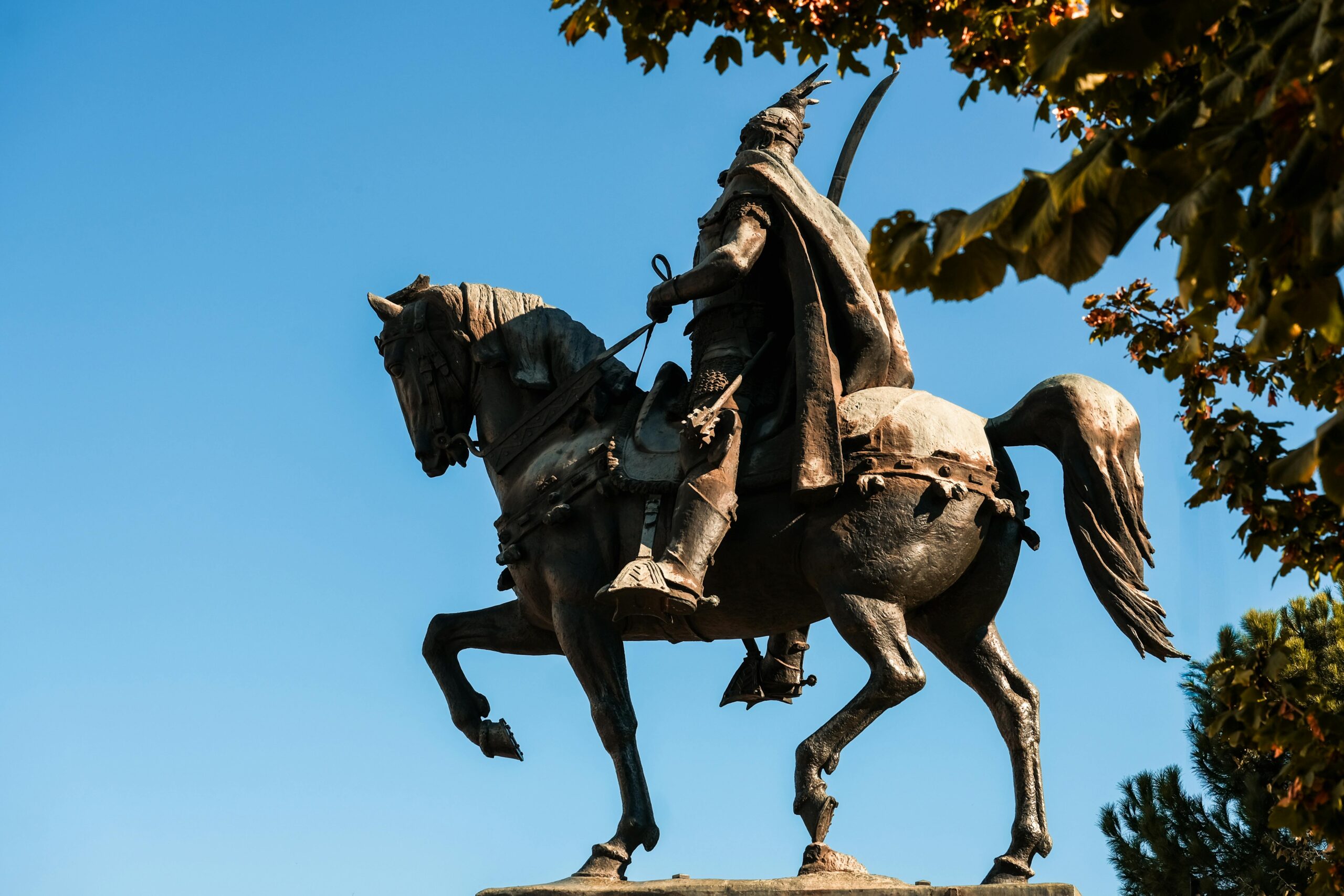 Majestic statue of national hero Skanderbeg on horseback under a clear blue sky in Tirana.